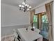 Dining room with chandelier and sliding glass doors to the balcony at 2220 Chianti Pl # 8-0828, Palm Harbor, FL 34683