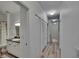 Hallway with neutral walls, hardwood floors and access to a bathroom with a shower and toilet at 2220 Chianti Pl # 8-0828, Palm Harbor, FL 34683