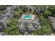 Aerial view of community pool and clubhouse surrounded by lush landscaping and umbrellas at 2220 Chianti Pl # 8-0828, Palm Harbor, FL 34683