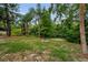 Backyard with a fire pit surrounded by lush greenery and mature trees, creating a private outdoor space at 2485 Indigo Dr, Clearwater, FL 33763