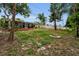 Large backyard featuring a screened-in porch, mature trees, a wooden deck, and a cozy fire pit area at 2485 Indigo Dr, Clearwater, FL 33763