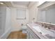Well-lit bathroom featuring a marble-topped vanity and shower-tub combo with neutral tile flooring at 2485 Indigo Dr, Clearwater, FL 33763