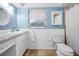 Light-blue bathroom featuring tiled counters, beadboard paneling, a mirror and white fixtures at 2485 Indigo Dr, Clearwater, FL 33763