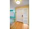 Entryway featuring light wood floors and a glass block window adjacent to the front door at 2485 Indigo Dr, Clearwater, FL 33763
