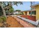 Charming yellow exterior with a red door, complimented by neat landscaping and walkway at 2485 Indigo Dr, Clearwater, FL 33763