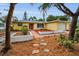 Charming single-story home with a red door, well-manicured landscaping and an attached garage at 2485 Indigo Dr, Clearwater, FL 33763