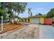 Charming yellow single-story home with a red door, well-manicured landscaping and an attached garage at 2485 Indigo Dr, Clearwater, FL 33763