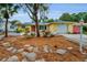 Charming yellow single-story home with a red door, well-manicured landscaping and an attached garage at 2485 Indigo Dr, Clearwater, FL 33763