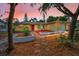 Charming yellow single-story home with a red door, well-manicured landscaping and an attached garage at 2485 Indigo Dr, Clearwater, FL 33763