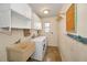 Functional laundry room with washer, dryer, sink, storage cabinets, and a quirky pegboard for hanging at 2485 Indigo Dr, Clearwater, FL 33763