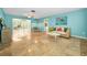 Bright and airy living room with travertine floors and a view into the enclosed sun room at 2485 Indigo Dr, Clearwater, FL 33763