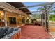 Screened-in deck with red wooden flooring, a hot tub, and a brick fireplace, and sliding doors to the house at 2485 Indigo Dr, Clearwater, FL 33763