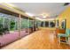 Enclosed sun room with wood floors, large windows, and access to a hot tub at 2485 Indigo Dr, Clearwater, FL 33763