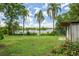 Lush backyard with towering palm trees and a serene lake view at 2814 W Humphrey St, Tampa, FL 33614