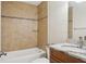Tiled bathroom featuring a bathtub and shower combination with glass shelf, and vanity with granite countertop at 2814 W Humphrey St, Tampa, FL 33614