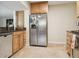 Well-lit kitchen featuring stainless steel refrigerator, wooden cabinets, and tile flooring at 2814 W Humphrey St, Tampa, FL 33614