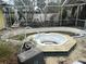 Screened-in pool area featuring a built-in hot tub and mature foliage at 2817 Miriam S St, Gulfport, FL 33711