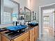 Bathroom with dual sinks, vessel sinks, granite countertops, and custom wood cabinets at 3001 Regal Oaks Blvd, Palm Harbor, FL 34684