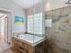 Modern bathroom features a soaking tub, glass block window, and tiled shower with a safety bar at 3001 Regal Oaks Blvd, Palm Harbor, FL 34684