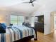 Bright bedroom with a ceiling fan, ensuite bathroom, and a view of the pool at 3001 Regal Oaks Blvd, Palm Harbor, FL 34684