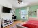 Well-lit bedroom with hardwood floors, desk, and outdoor views at 3001 Regal Oaks Blvd, Palm Harbor, FL 34684
