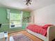 Bright bedroom with hardwood floors and a large window overlooking backyard at 3001 Regal Oaks Blvd, Palm Harbor, FL 34684