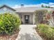 Close-up of the front door entrance with a stone pathway surrounded by lush landscaping at 3001 Regal Oaks Blvd, Palm Harbor, FL 34684