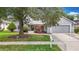 Charming single-story home featuring a well-maintained lawn, mature trees, and an attached two-car garage at 3001 Regal Oaks Blvd, Palm Harbor, FL 34684