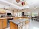 Open-concept kitchen with granite counters, wood cabinets, island with beverage cooler and breakfast nook at 3001 Regal Oaks Blvd, Palm Harbor, FL 34684