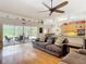 Bright living space featuring hardwood floors, sliding glass doors, and an adjacent kitchen area at 3001 Regal Oaks Blvd, Palm Harbor, FL 34684