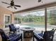 Screened-in patio with an outdoor seating area, a fire pit table, and views of the pool and lush backyard at 3001 Regal Oaks Blvd, Palm Harbor, FL 34684