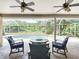 Inviting screened-in patio with cozy lounge chairs, stylish fire pit table, and serene views of the sparkling pool at 3001 Regal Oaks Blvd, Palm Harbor, FL 34684