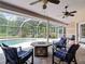 Covered patio featuring an outdoor lounge area with comfortable seating, a fire pit table, and a view of the screened-in pool at 3001 Regal Oaks Blvd, Palm Harbor, FL 34684