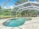 Screened-in pool with stone deck and a view of natural landscaping and scenic water views at 3001 Regal Oaks Blvd, Palm Harbor, FL 34684