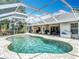 Backyard with a screened-in pool with stone deck, patio, and a view of a home at 3001 Regal Oaks Blvd, Palm Harbor, FL 34684
