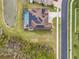Aerial view of a property featuring a pool, backyard pond, and solar panels at 32122 Wenlock Loop, Wesley Chapel, FL 33543