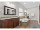 Bathroom features a soaking tub, dark wood cabinets, granite countertops, and a separate shower area at 32122 Wenlock Loop, Wesley Chapel, FL 33543