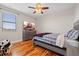 Serene bedroom with hardwood floors, neutral walls, ceiling fan, a comfortable bed, and ample natural light at 32122 Wenlock Loop, Wesley Chapel, FL 33543