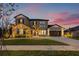 Charming two-story home featuring a manicured lawn, stone accents, and a spacious three-car garage at 32122 Wenlock Loop, Wesley Chapel, FL 33543