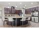 Open kitchen with granite counters, an island with seating and stainless steel appliances at 32122 Wenlock Loop, Wesley Chapel, FL 33543