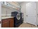 Convenient laundry room boasts modern washer and dryer, sink, granite counters, stylish backsplash and ample storage at 32122 Wenlock Loop, Wesley Chapel, FL 33543