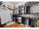 Well-organized walk-in closet with multiple hanging rods, shelving, and dedicated shoe storage at 32122 Wenlock Loop, Wesley Chapel, FL 33543
