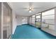 Enclosed sunroom with ceiling fan, sliding glass door, and blue carpeting at 3243 Eisenhower Dr, Holiday, FL 34691