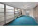 Enclosed sunroom featuring sliding glass door, windows and blue carpet at 3243 Eisenhower Dr, Holiday, FL 34691