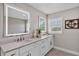 Bathroom featuring white cabinets, double sinks, and an illuminated mirror at 330 Palm Ne Is, Clearwater Beach, FL 33767