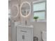 Modern bathroom with a circular illuminated mirror, sleek vanity, and glass-enclosed shower stall at 330 Palm Ne Is, Clearwater Beach, FL 33767