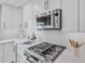 Bright kitchen featuring white cabinets, stainless steel appliances, and a gas range with stone countertops at 330 Palm Ne Is, Clearwater Beach, FL 33767