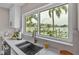 Kitchen sink overlooking tropical waterfront with palm trees and boats, enhancing the view from the counter at 330 Palm Ne Is, Clearwater Beach, FL 33767