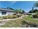Manicured backyard has a patio with dining set, landscaping and partial fencing at 3357 Hunt Club Dr, Clearwater, FL 33761