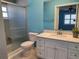 Bathroom boasts a modern shower with a sliding glass door, updated vanity, and calming blue walls at 3357 Hunt Club Dr, Clearwater, FL 33761